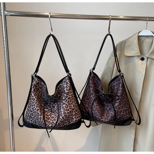Detail of leopard print tote bags with black bows hanging on a metal rack