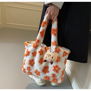 Detail of white plush tote bag with 3D orange floral pattern and puppy charm