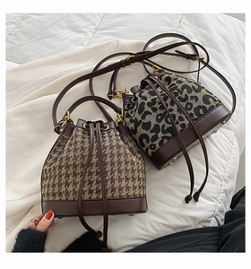 Detail of leopard print and houndstooth bucket bags with drawstring and leather straps