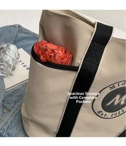 Primer plano del bolsillo lateral del bolso tote de lona con paraguas y detalle de logo