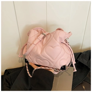 Close-up of pink heart-quilted leather bag with silver chain strap and drawstring closure
