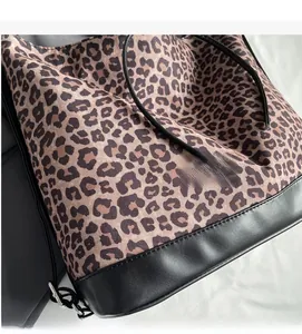 Detail of leopard print tote bag showing durable canvas texture and black leather trim