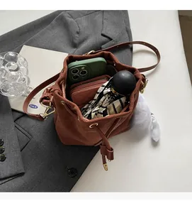 Macro view showing spacious interior of the brown suede bucket bag with daily items