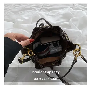 Detailed interior capacity of leopard print bucket bag with brown leather trim and gold chain