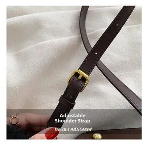 Close-up of adjustable brown leather shoulder strap with a polished gold pin buckle detail