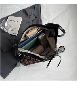 Interior view showing the large capacity of a leopard print tote bag with daily items