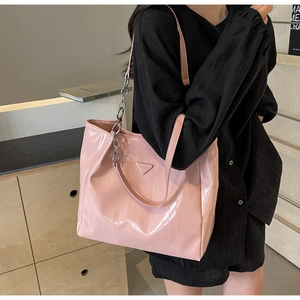 Pink patent leather tote bag detail with chunky silver chain and logo on shoulder strap