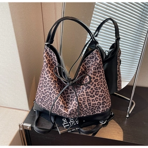Close-up of leopard print tote bag with black bow detail and reinforced leather handles