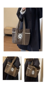 Detalle del bolso tote de lona marrón oscuro con ribete blanco y parche de logo redondo
