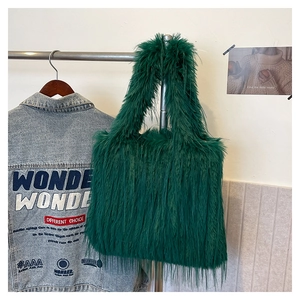 Texture détaillée du cabas en fausse fourrure vert foncé dans un décor de mode