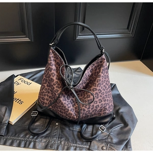 Close-up of leopard print tote bag with black leather base and elegant bow detail