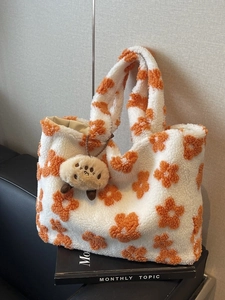 Sherpa fleece tote bag with orange floral pattern and cute plush charm on book