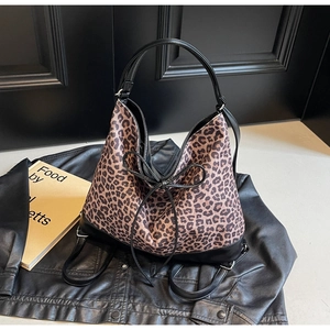 Detail of leopard print tote bag with black leather straps and decorative bow knot
