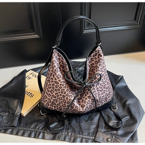 Detail of leopard print hobo bag with black leather trim and decorative bow tie