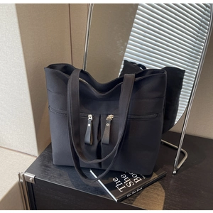 Grande borsa tote in tela nera con doppie tasche con zip su scrivania in legno