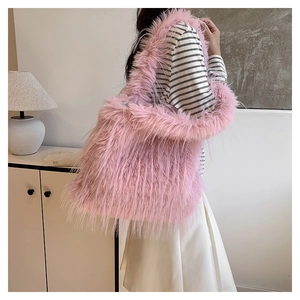 Détail de la texture en fausse fourrure rose du sac cabas porté par un mannequin en intérieur