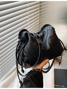 Black heart-quilted shoulder bag with silver chain strap and drawstring closure