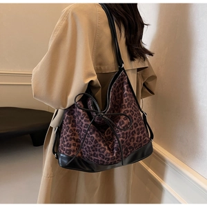 Detail of large leopard print tote bag worn by model over a light trench coat