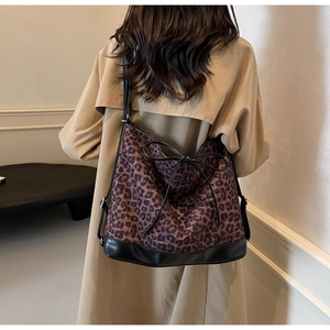 Detail of leopard print tote bag featuring a black bow and adjustable shoulder strap