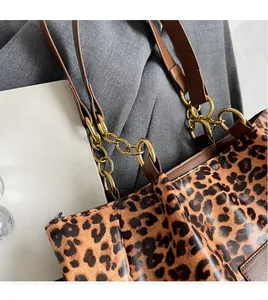 Close-up of leopard print shoulder bag featuring gold chain strap and leather trim