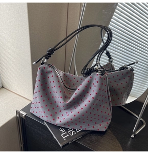 Gros plan d'un sac cabas en nylon à motifs cœurs avec bandoulières en corde noire