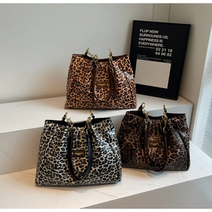 Three leopard print tote bags in orange, grey and brown colors on marble stairs