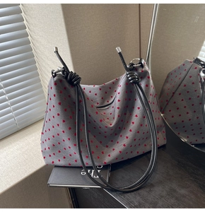 Détail du sac cabas gris avec motifs cœurs rouges et anse en corde noire
