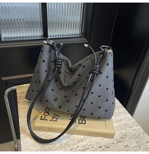 Gros plan détaillé du sac cabas gris à pois avec broderie nœud noir et fermeture éclair