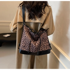 Detailed back view of large leopard print tote bag with black leather straps and drawstring