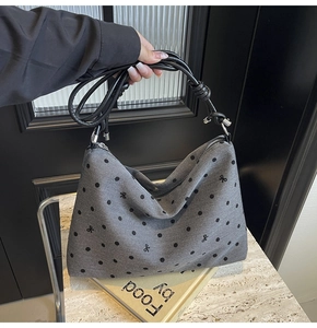 Gros plan d'un sac cabas en nylon gris avec motifs à pois noirs et nœuds décoratifs