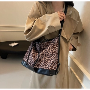Leopard print bucket bag with drawstring detail styled on a model in beige coat