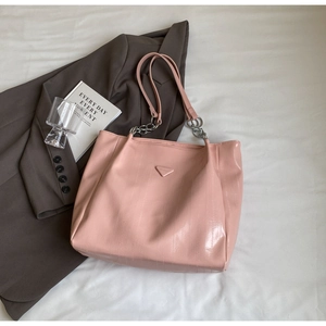 Detail of pink faux leather tote bag with subtle metallic sheen and silver chain strap