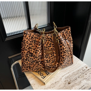 Close-up of leopard print tote bag featuring gold chain handle on aesthetic background