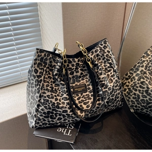 Detailed view of leopard print tote bag with gold chain strap and chic leather brand tag