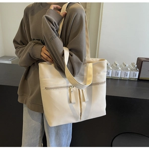 Dettaglio della borsa tote in tela color crema con zip frontale e stile minimale