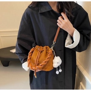 Brown bucket bag featuring a woven handle and a cute white cloud plush charm detail