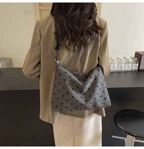 Détail du sac cabas gris à pois montrant le tissu épais et la bandoulière noire fine