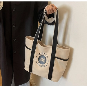 Detalle del bolso tote de lona con asa negra y logotipo de Midolay vintage