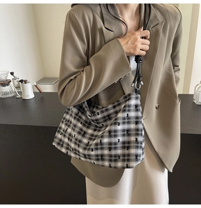Détail du grand sac cabas à carreaux avec broderie ours et bandoulière en cuir noir