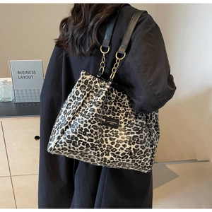 Detail of leopard print tote bag with black leather and gold metal chain strap for women