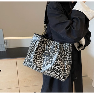 Detail of large leopard print tote bag with stylish gold chain strap and branding