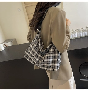 Sac fourre-tout en nylon à pois avec détails de nœuds noirs porté à l'épaule sur modèle