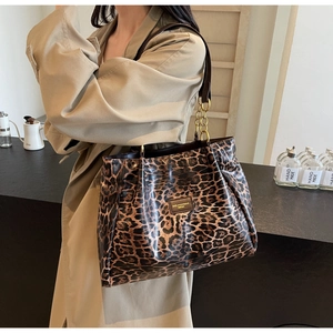 Detailed view of the leopard print faux leather tote with brown strap and gold chain