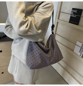 Détail du sac cabas en tissu gris avec motifs de cœurs rouges et bandoulière nouée