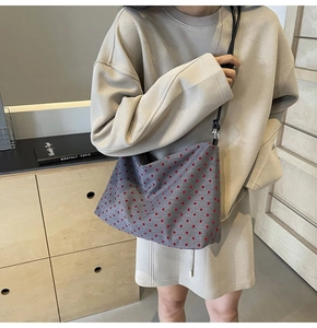 Détail du sac fourre-tout en toile grise avec motifs cœurs rouges et bandoulière