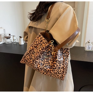 Macro view of leopard print tote bag with golden chain and brown leather shoulder straps