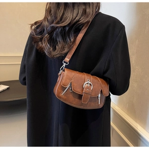 Detailed back view of vintage brown leather saddle bag with silver buckle and zippers