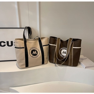 Vista detallada de bolsos tote de lona en beige y café para el uso diario urbano