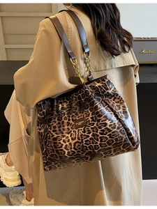Leopard print tote bag with gold chain straps and leather logo shown in lifestyle setting