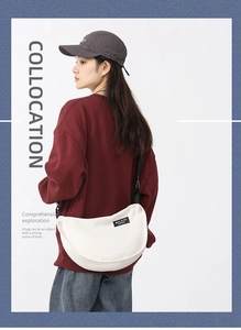 Large white nylon crescent bag with adjustable black strap shown on female model